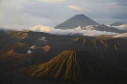 A beautiful scenery consisting of multiple clouded volcanos.