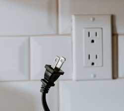 A plug in front of a wall with a socket