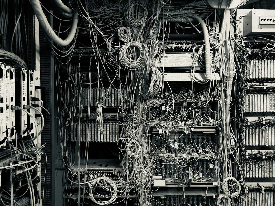 A server room with lots of cables running into hardware. It looks very messy.