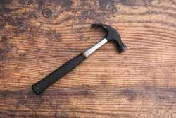 Photo of a hammer on a wooden background